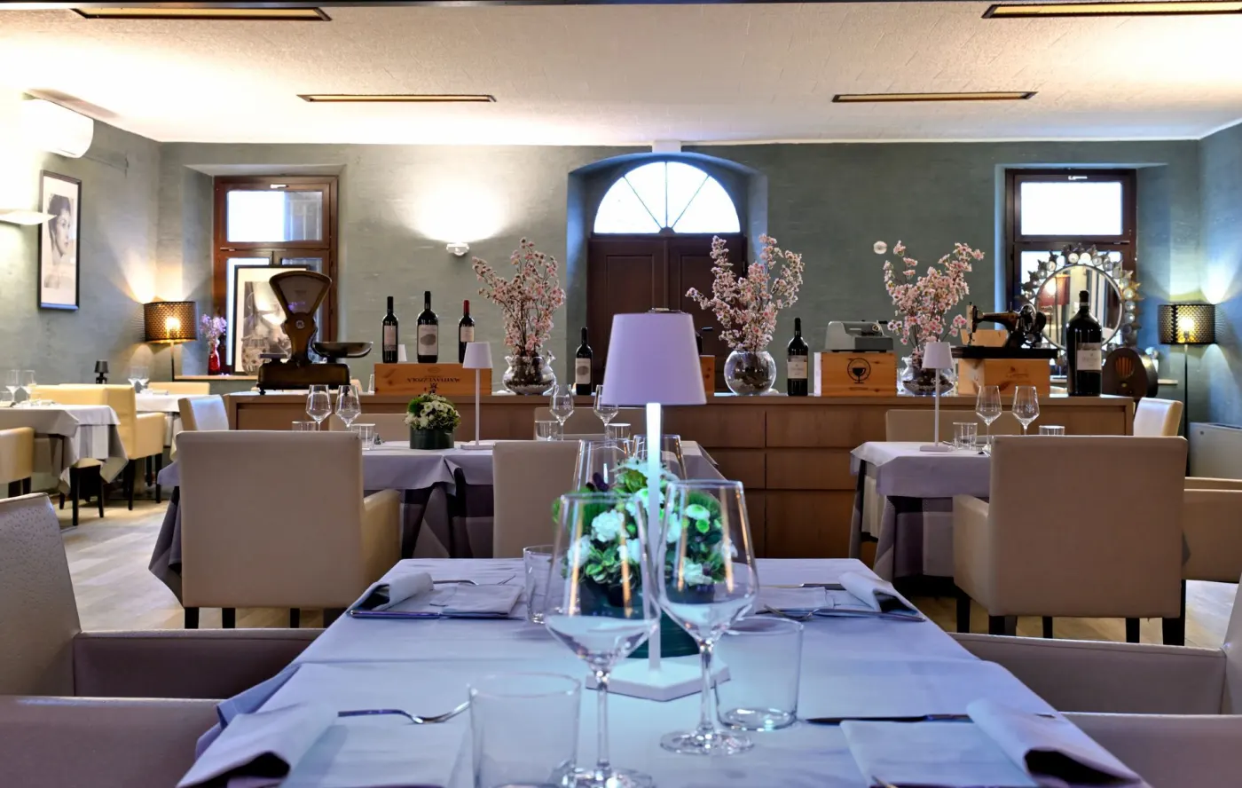 La sala apparecchiata per una cena, con la porta ad arco sullo sfondo