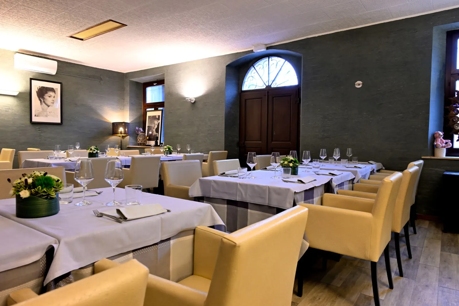 La sala dell'osteria con le poltroncine e i ritratti d'epoca alle pareti