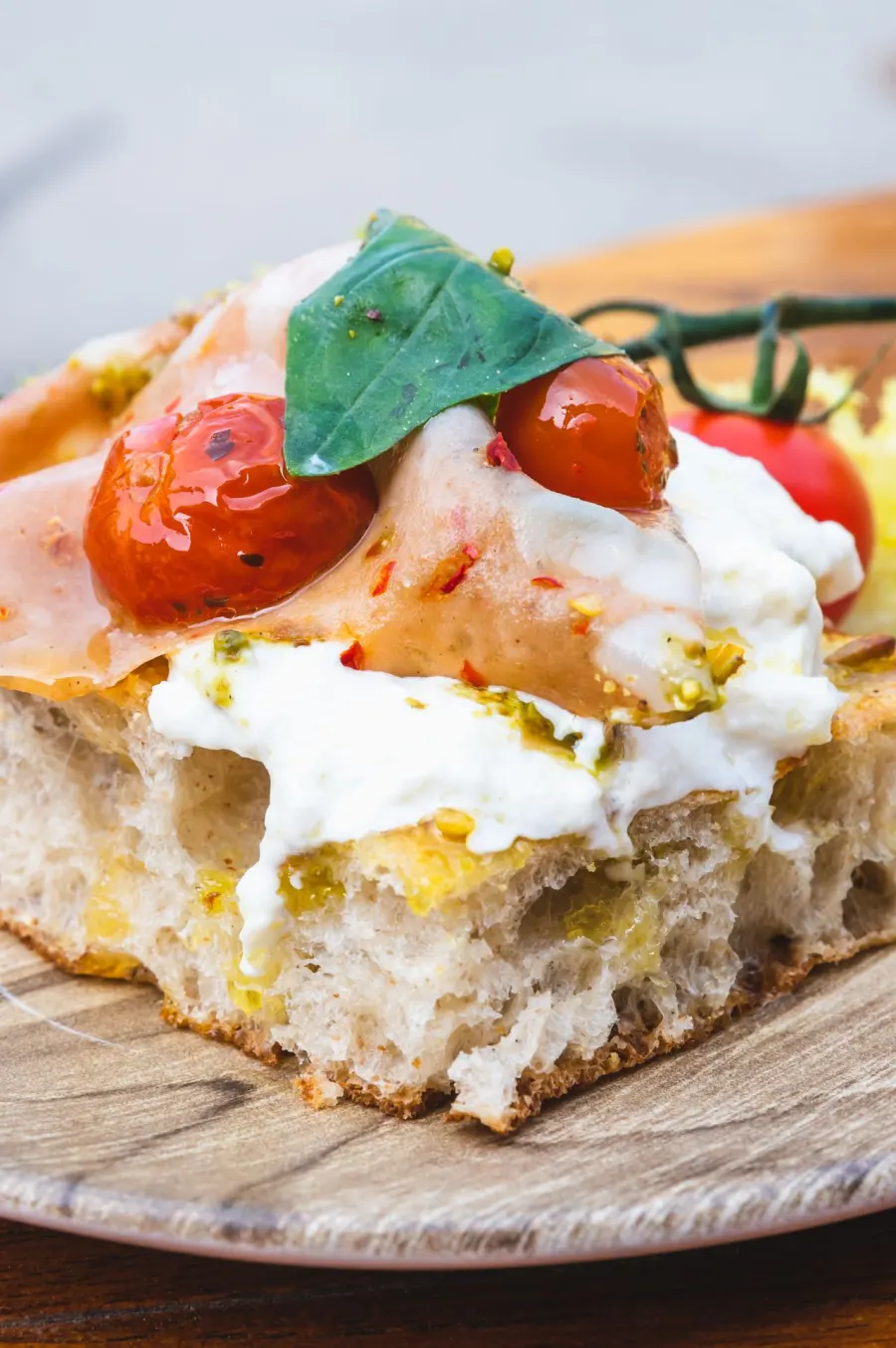 Trancio di pizza al tegamino con crudo, burrata e pomodorini